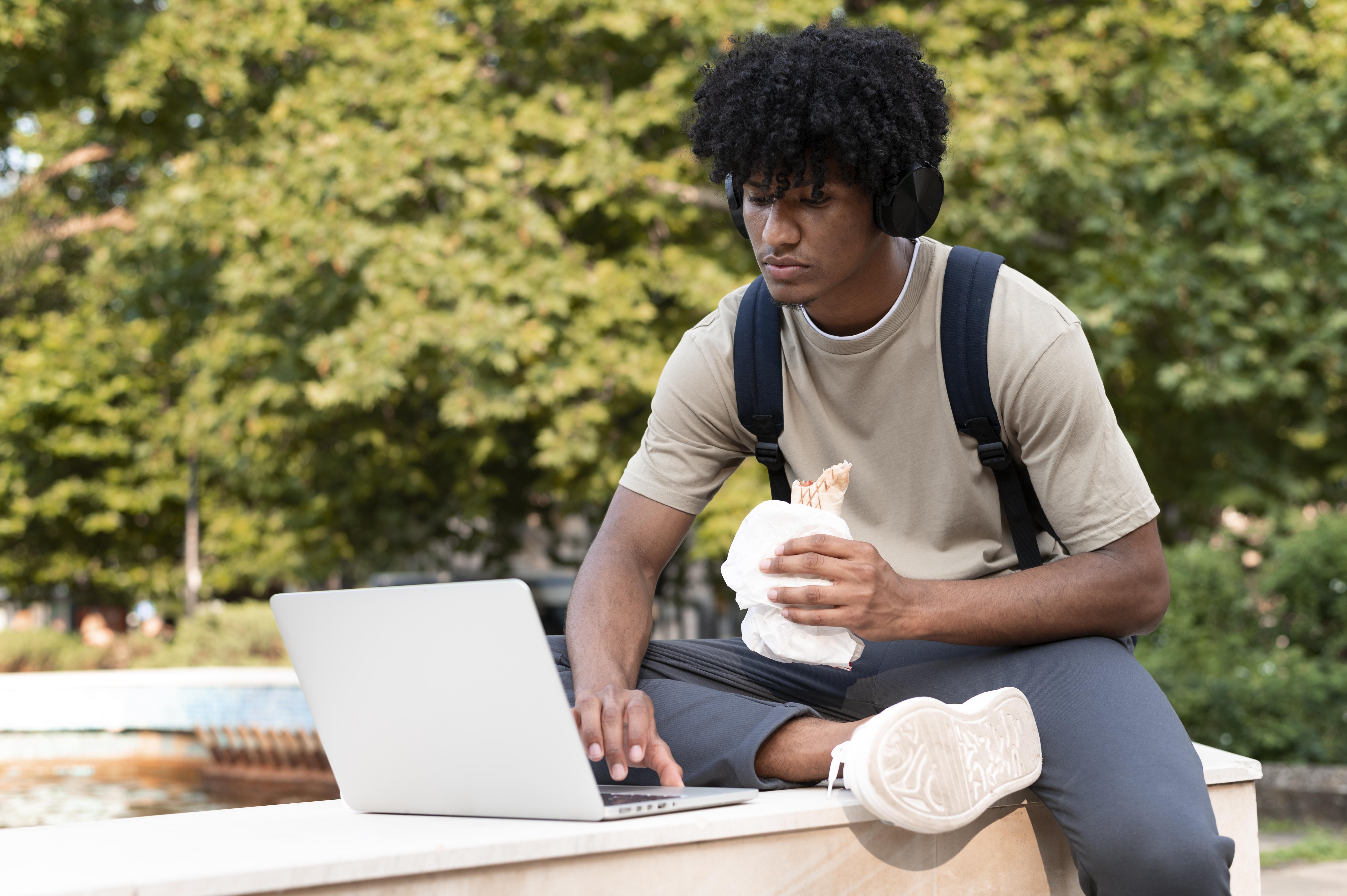 Student sitting on steps using laptop