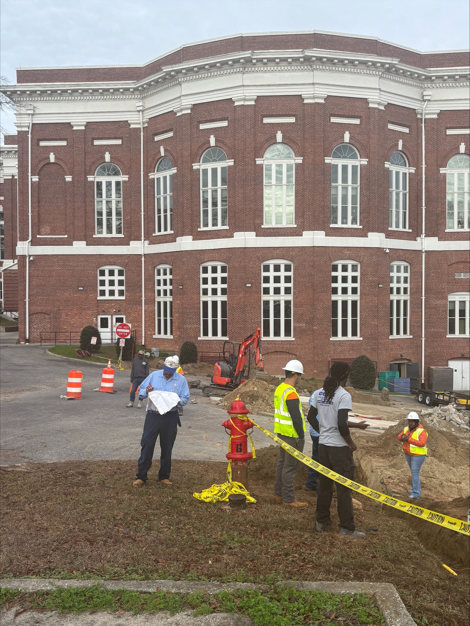 Workers repairing gas line behind building