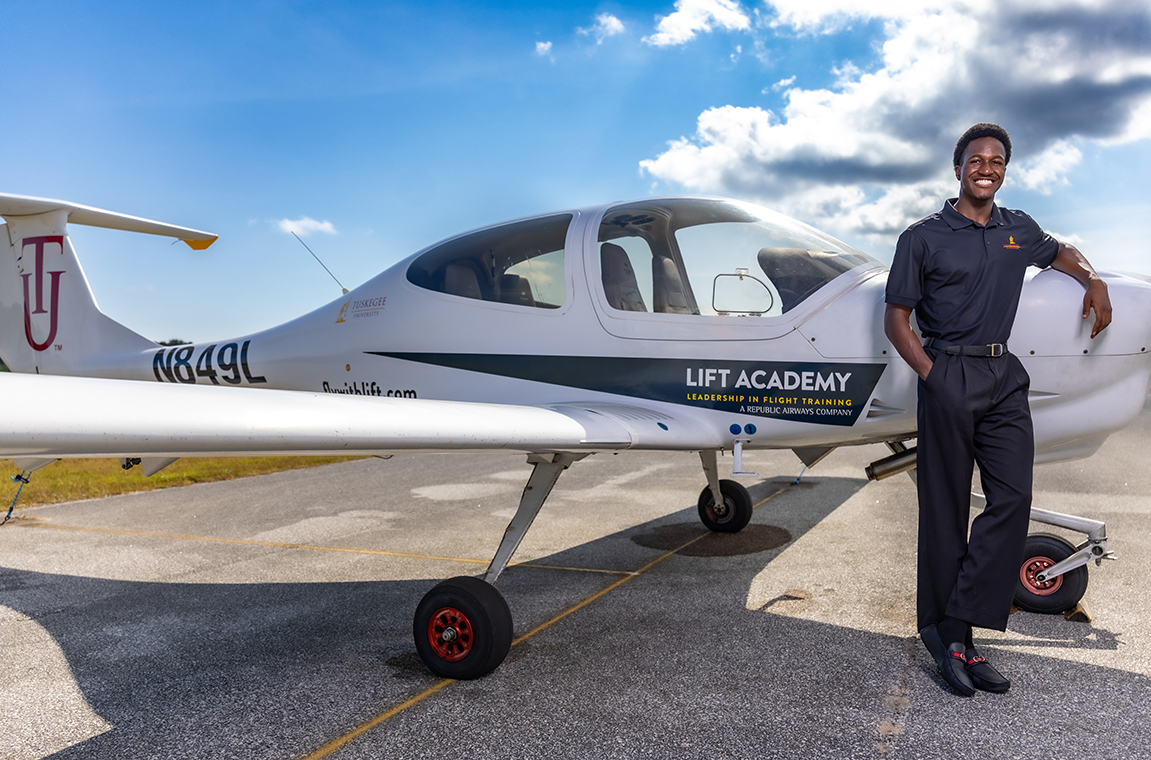 Student pilot standing by small airplane