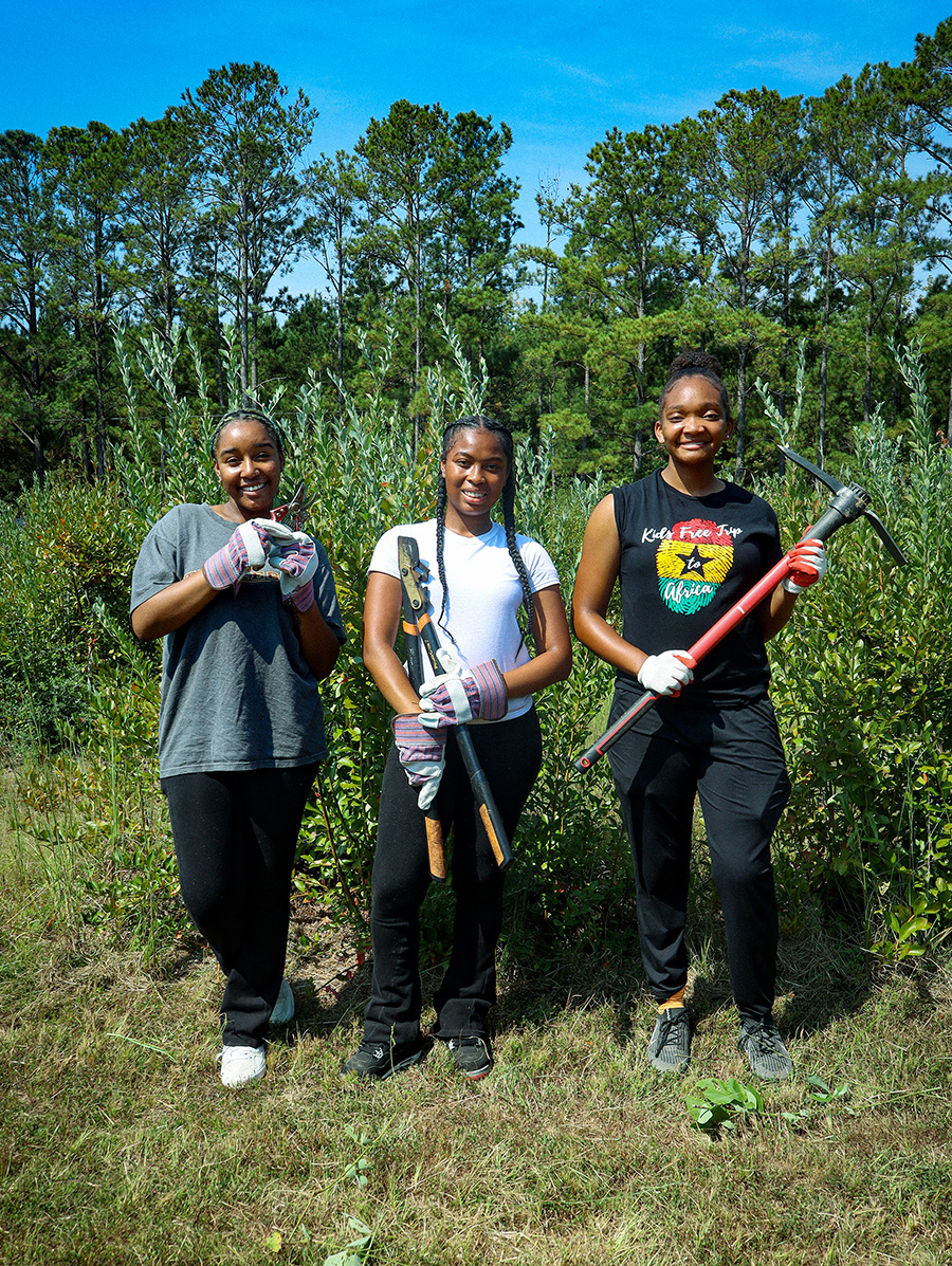 Three students working in a garden