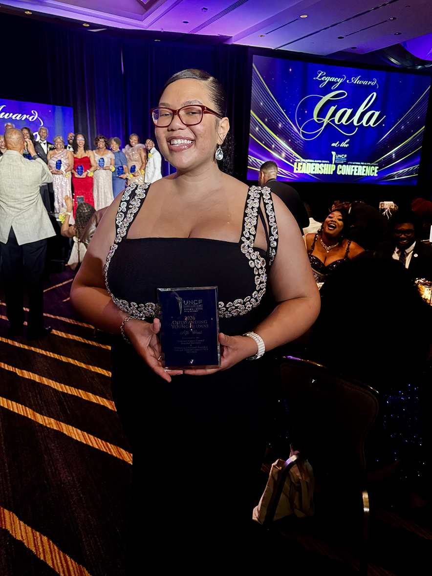 Female young alumni holding award