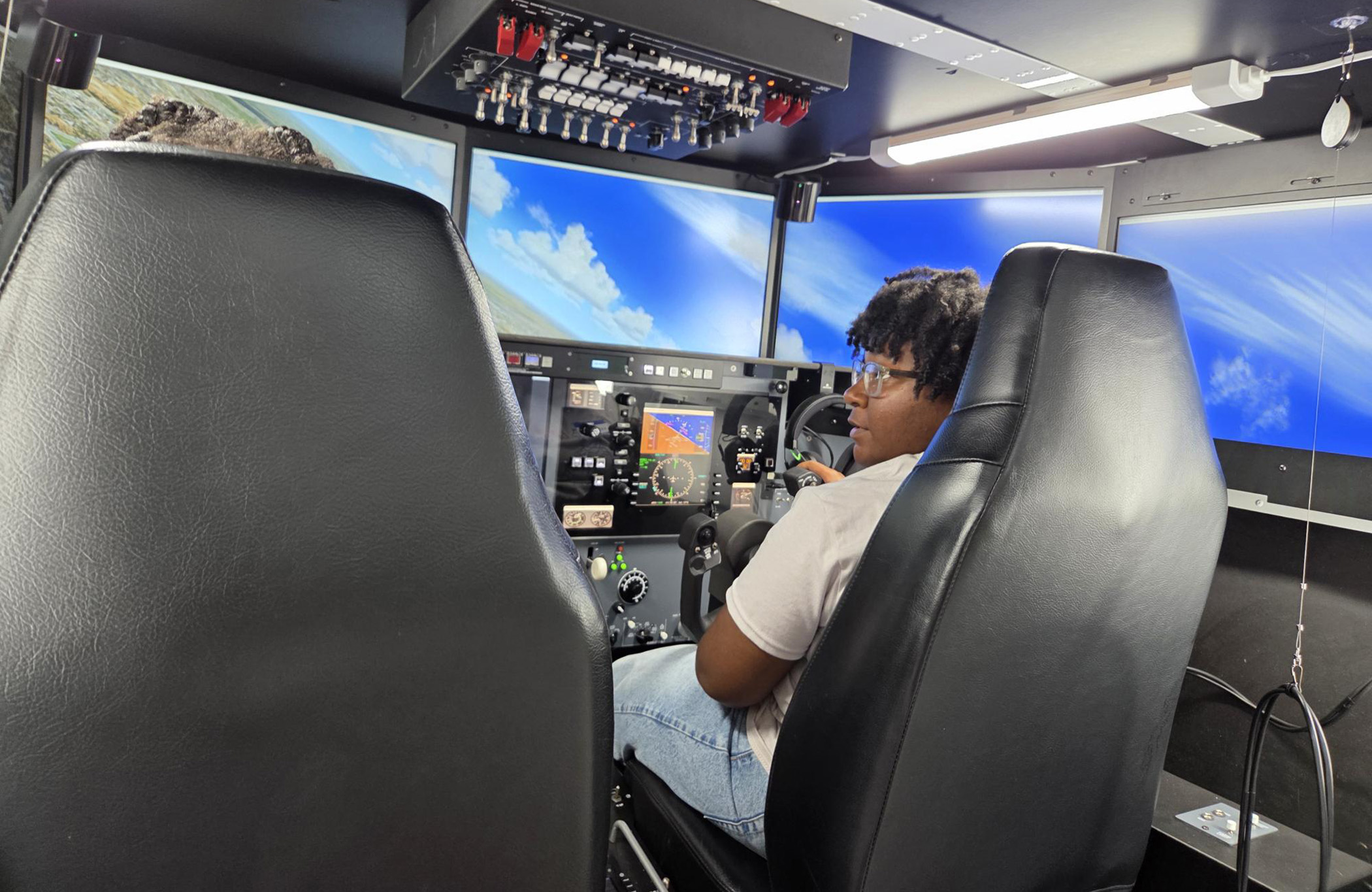 Aviation student Kembriah Parker trains girls on a flight simulator.