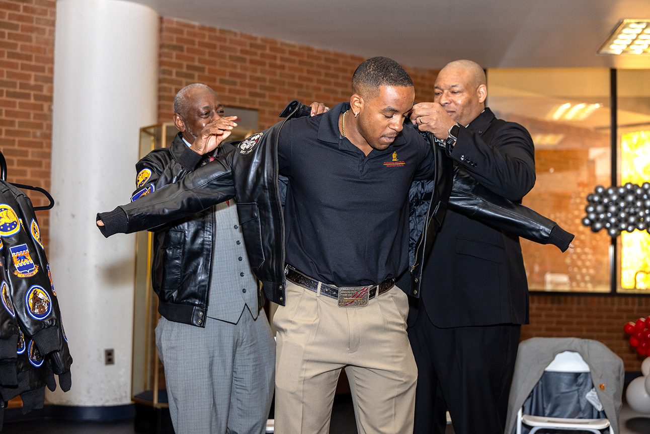 Dr. Brown and Capt. Sanders helps put jacket on a male aviation student