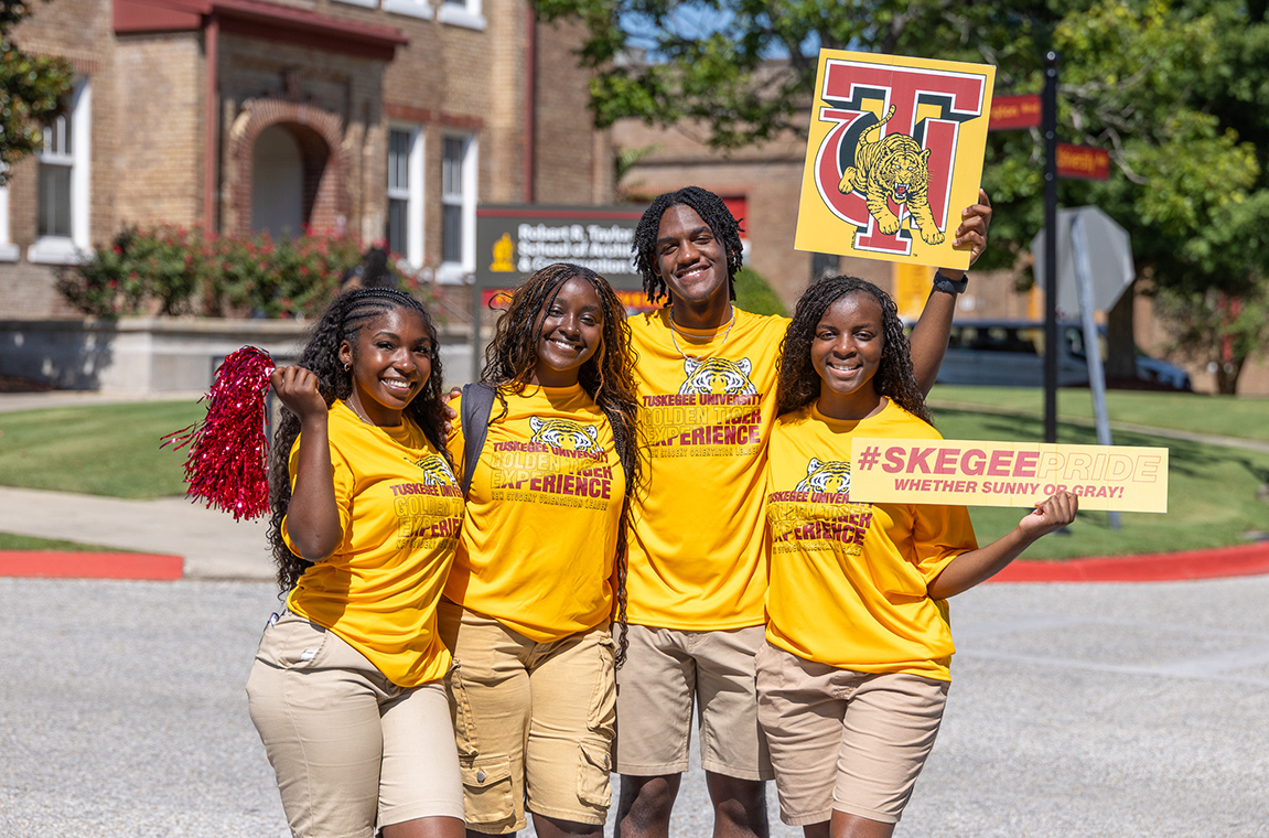 New Student Orientation Leaders welcoming new students and their families at the entrance to campus