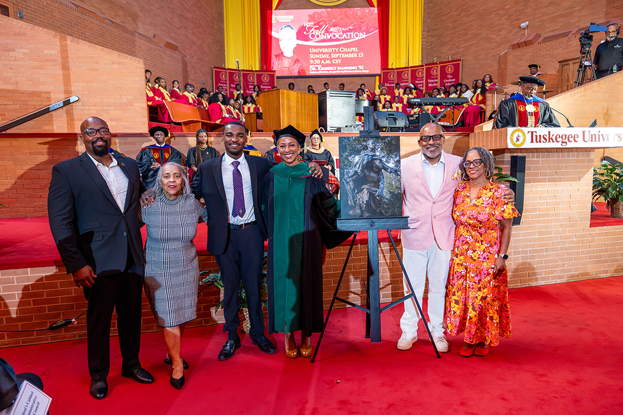 Dr. Kimberly Manning and her family stand by the Booker T. Washington print