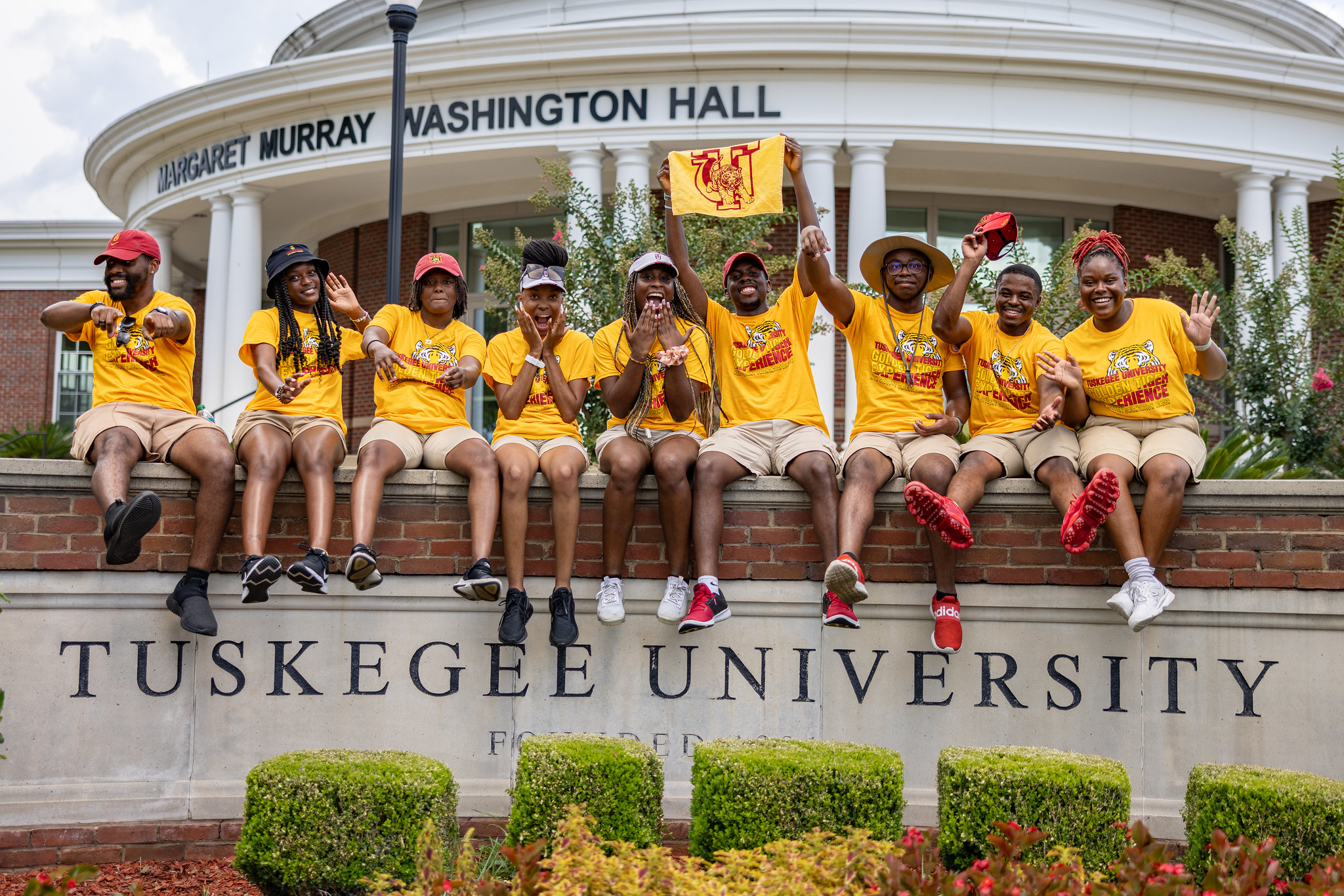 Students on the Tuskegee University sign at the main entrance