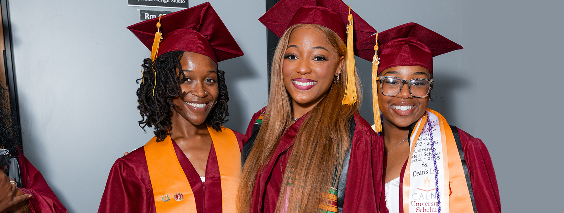 Three female grads in cap and gowns