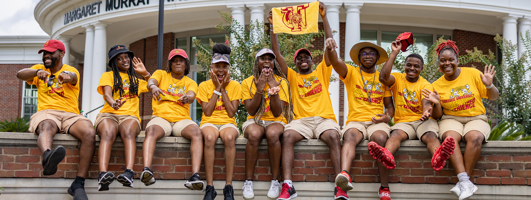 Student Greeters sitting on a wall