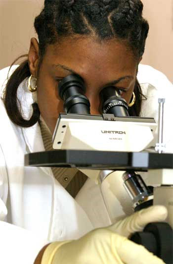 A female technician using a microscope