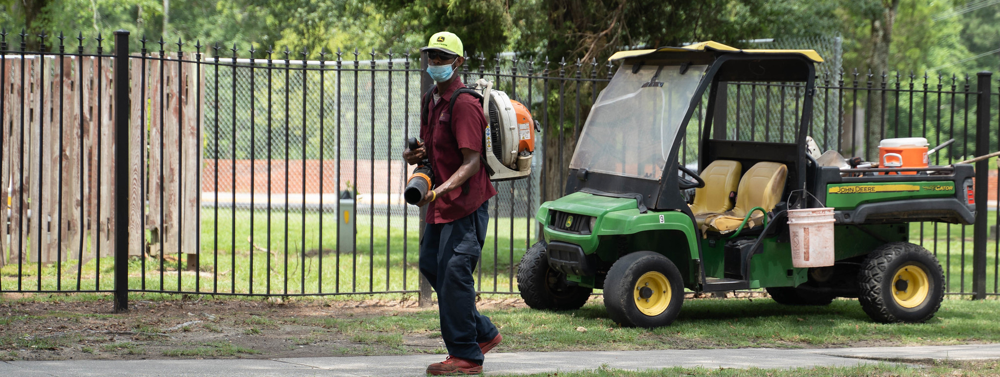 Maintenance worker with equipment on golf cart