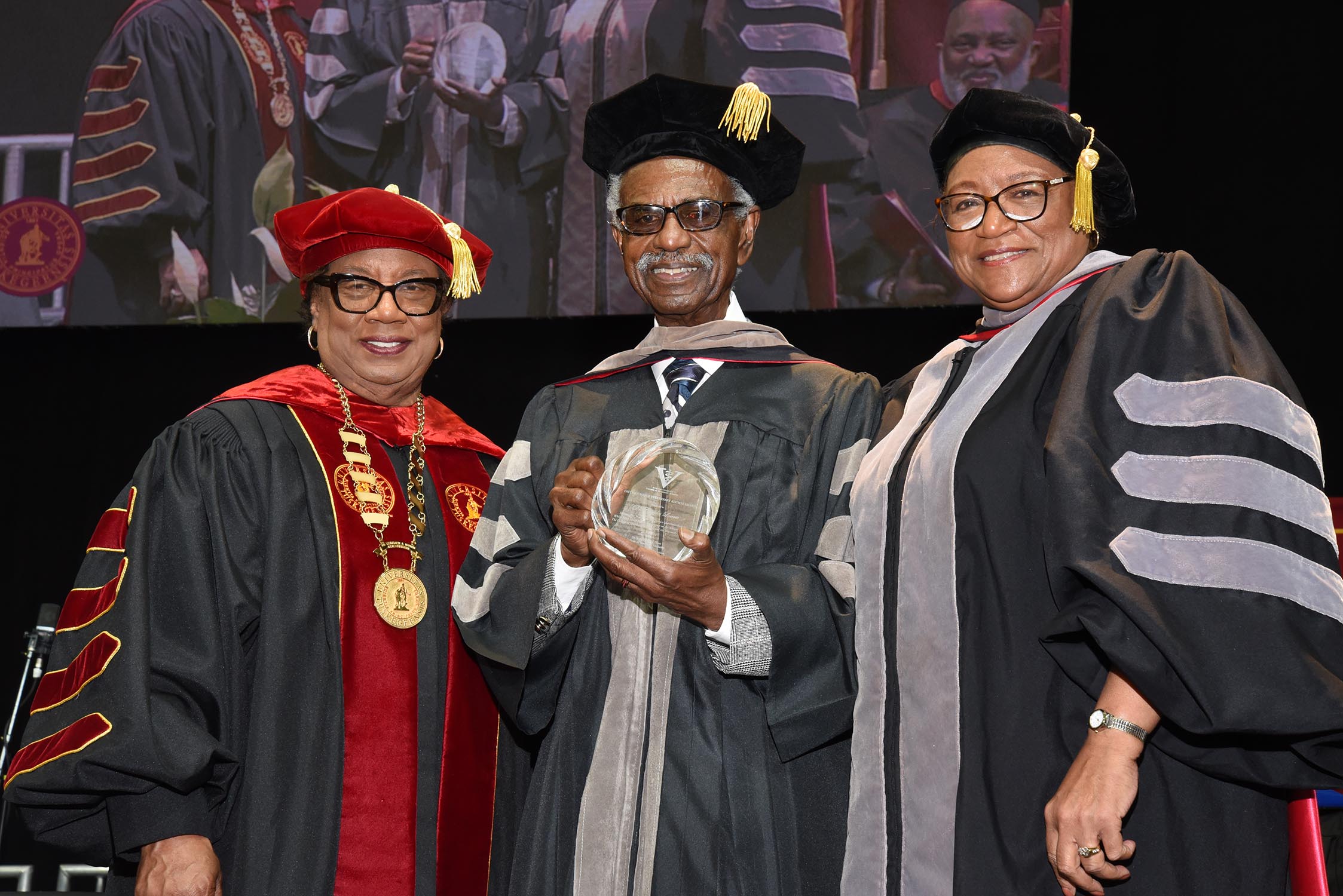 Dr. Charles Lowrie (center) receives award from President Morris and Dean Perry.