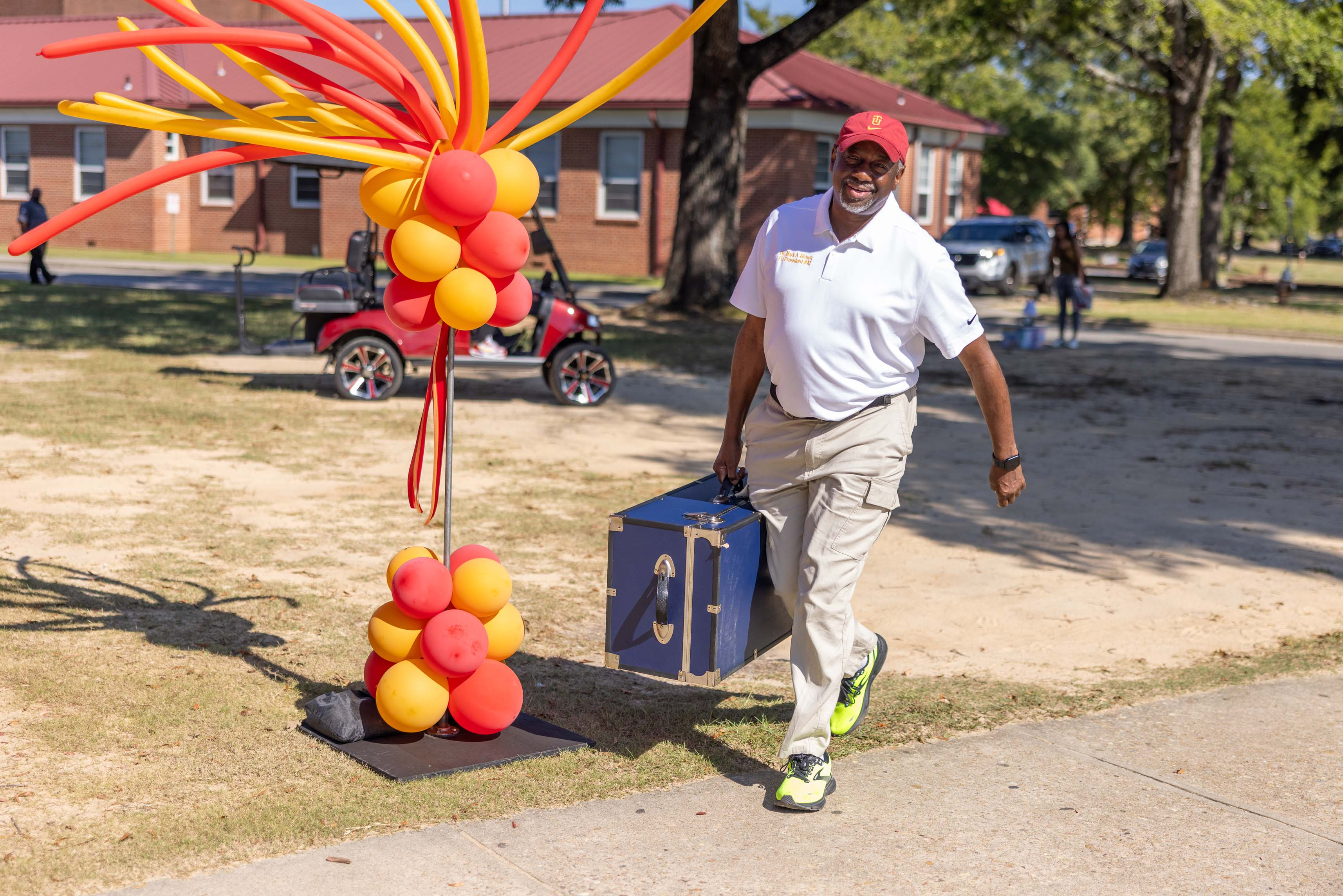 President Brown carries footlocker for a student.