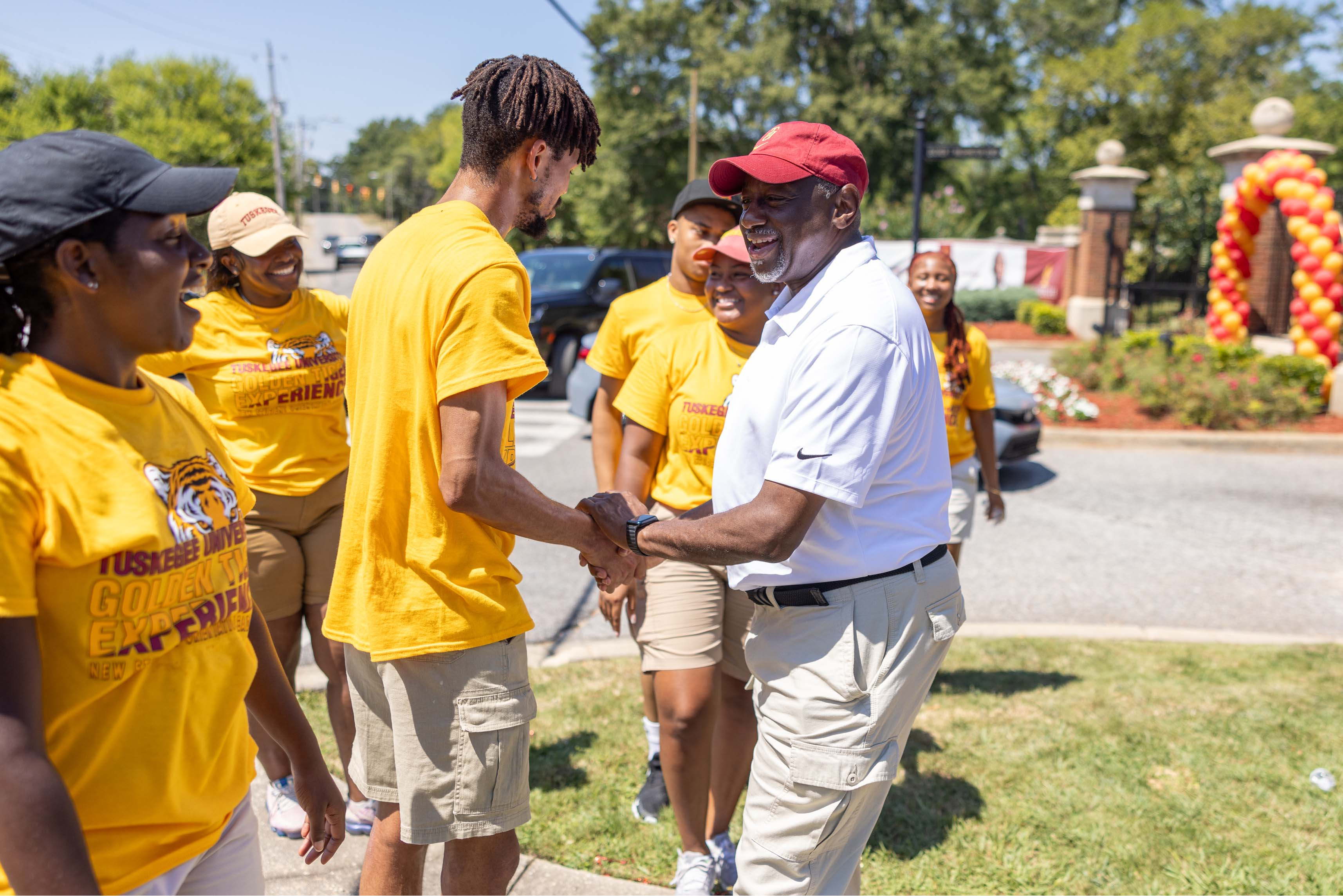 President Brown shakes hands with student greeters.