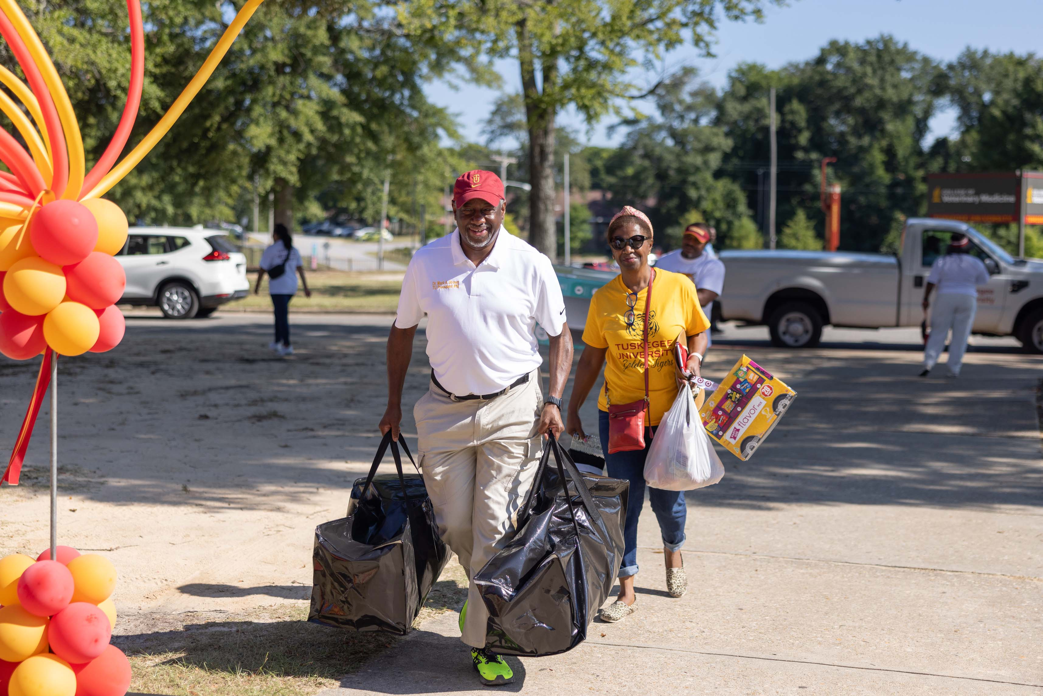 President and First Lady Brown assist students in carrying items into dorm.