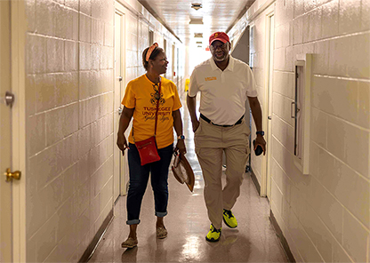 President Mark Brown and First Lady Gwen Brown in dorm hallway.