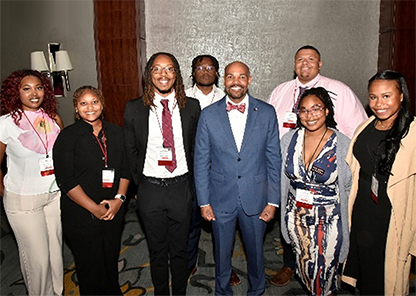 Keynote speaker and 20th Surgeon General Dr. Jerome Adams (center) engages with veterinary students and student leaders after his presentation.