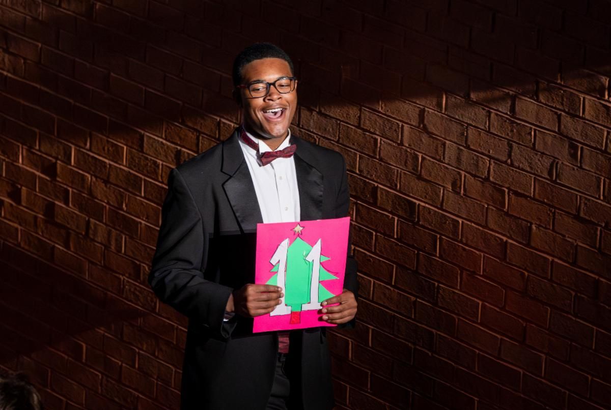 Choir member holding a section number