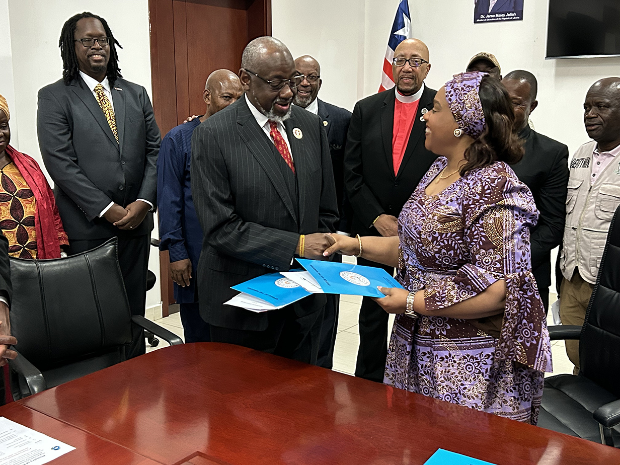 Dr. Mark Brown exchanges MOU documents with Minister of Education Dr. Jallah