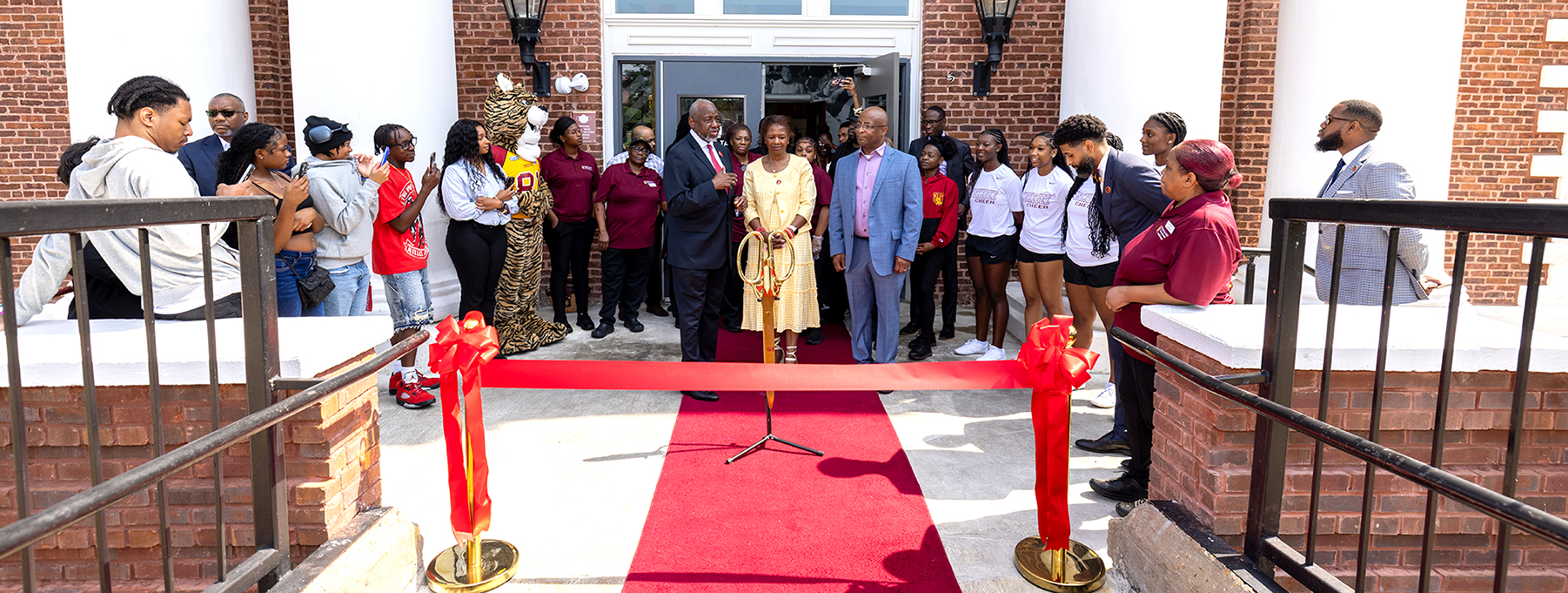Dr. and Mrs. Brown, university officials and students cutting the ribbon on the refurbished cafeteria