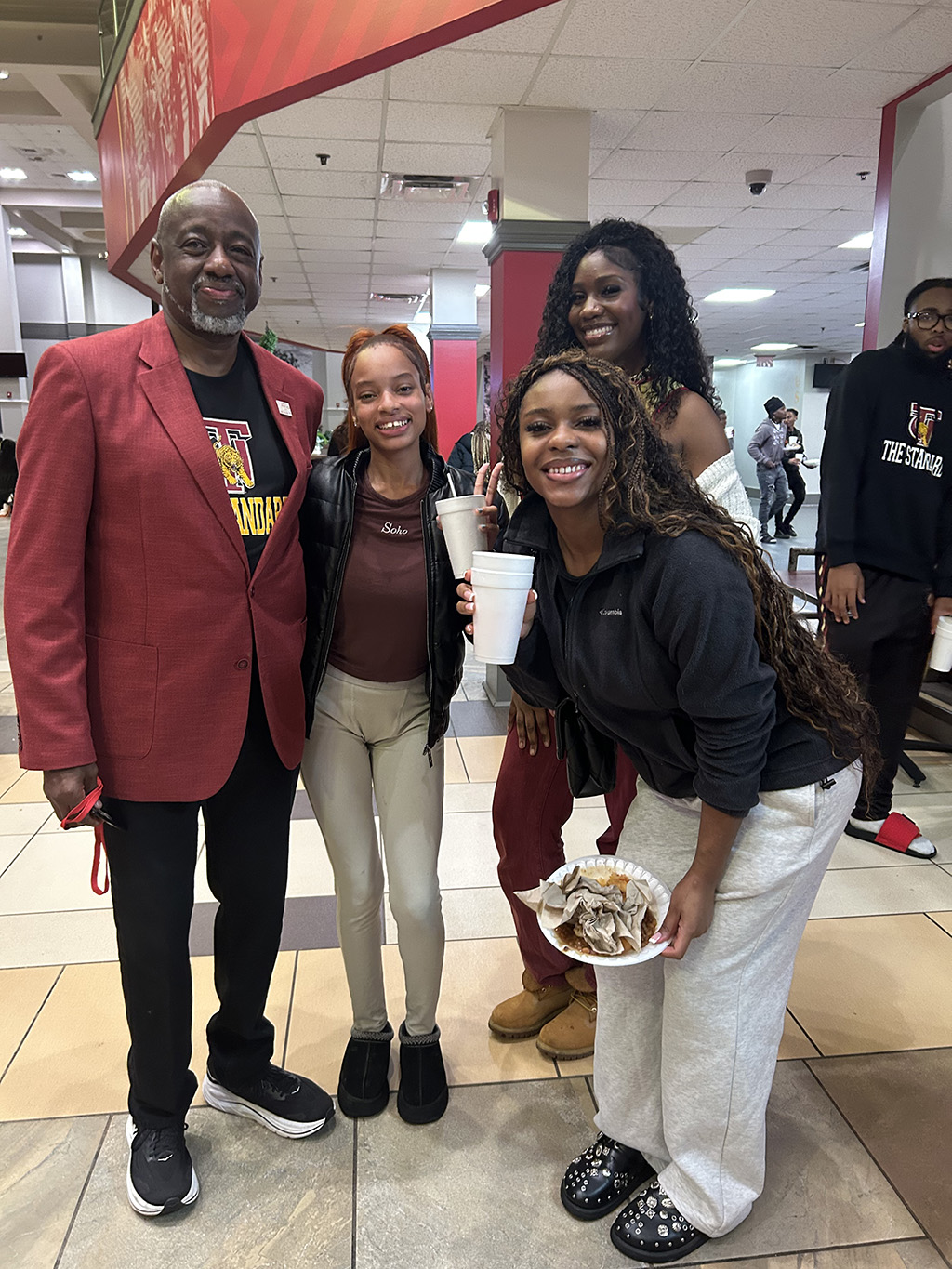 Dr Brown posing with students the the cafeteria