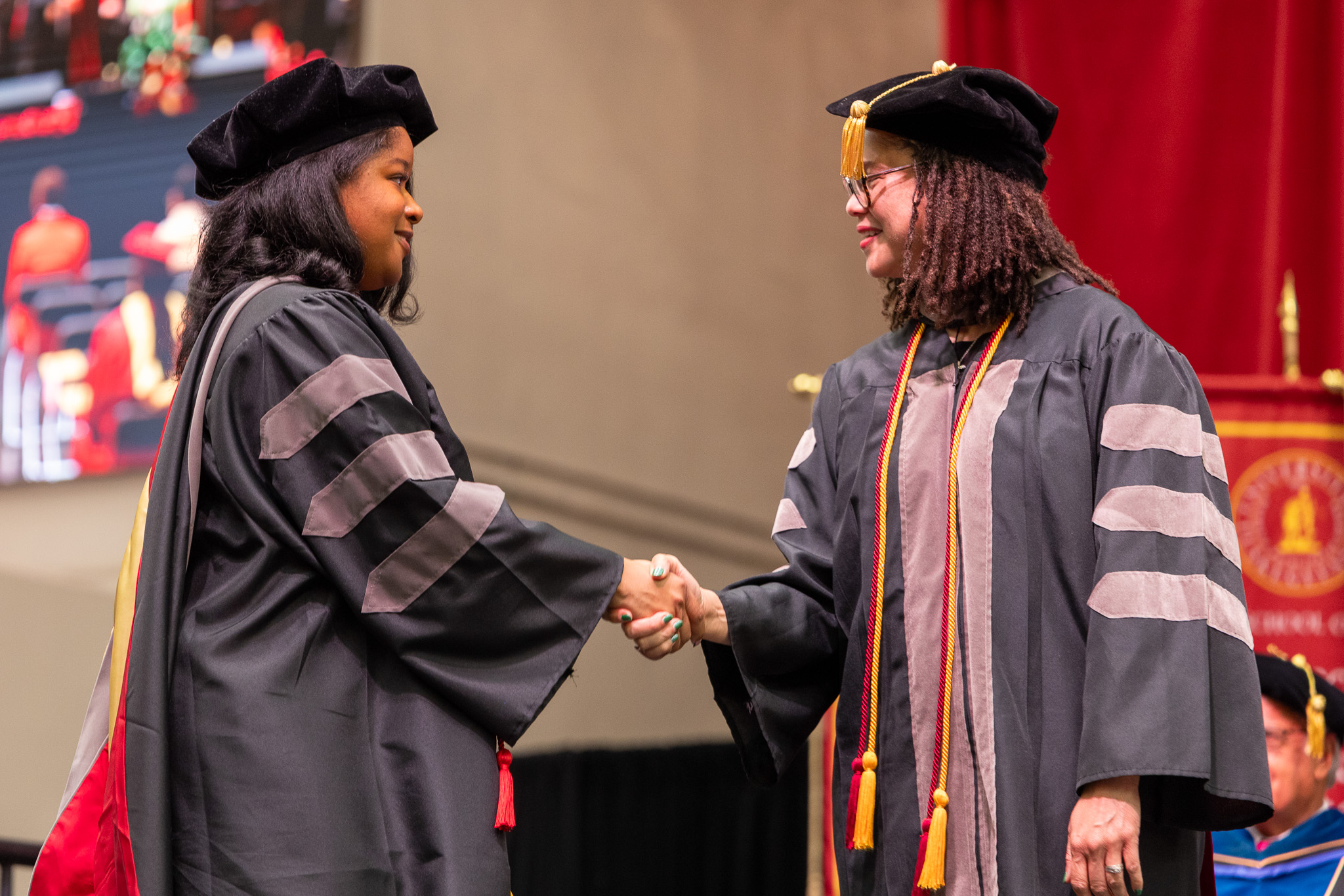 2026 Grad Commencement student shakes hands with Dean
