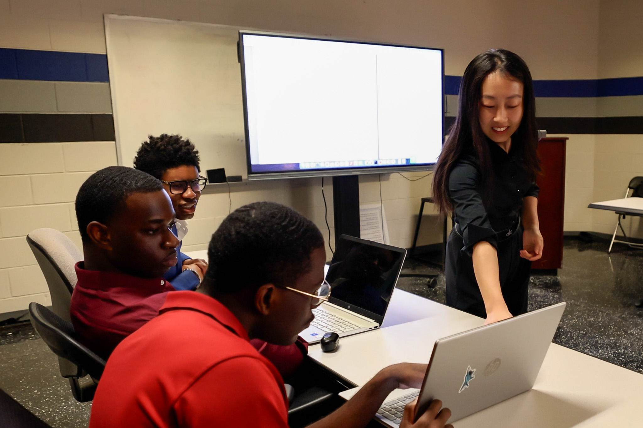 Dr. Yang explaining something to students on their laptop