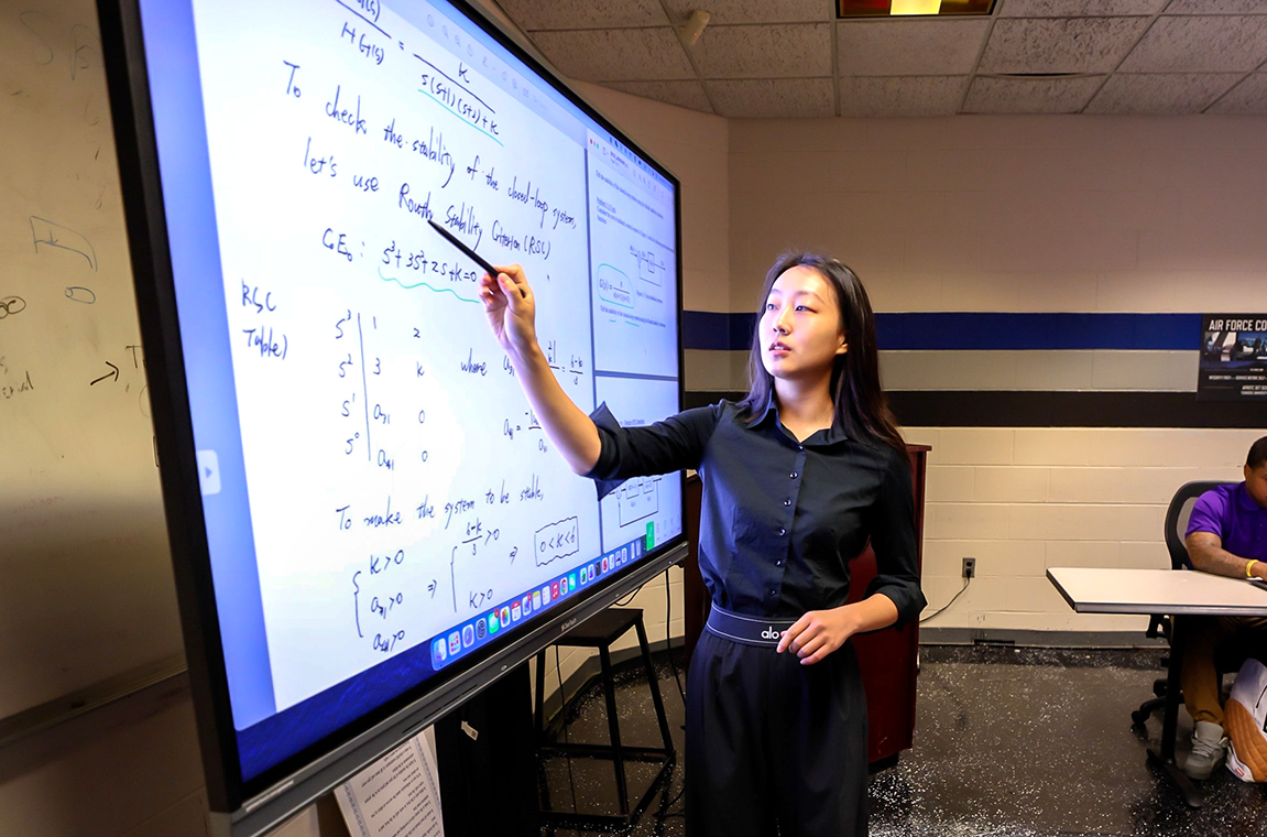 Dr. Shuting Yang at the board teaching a class