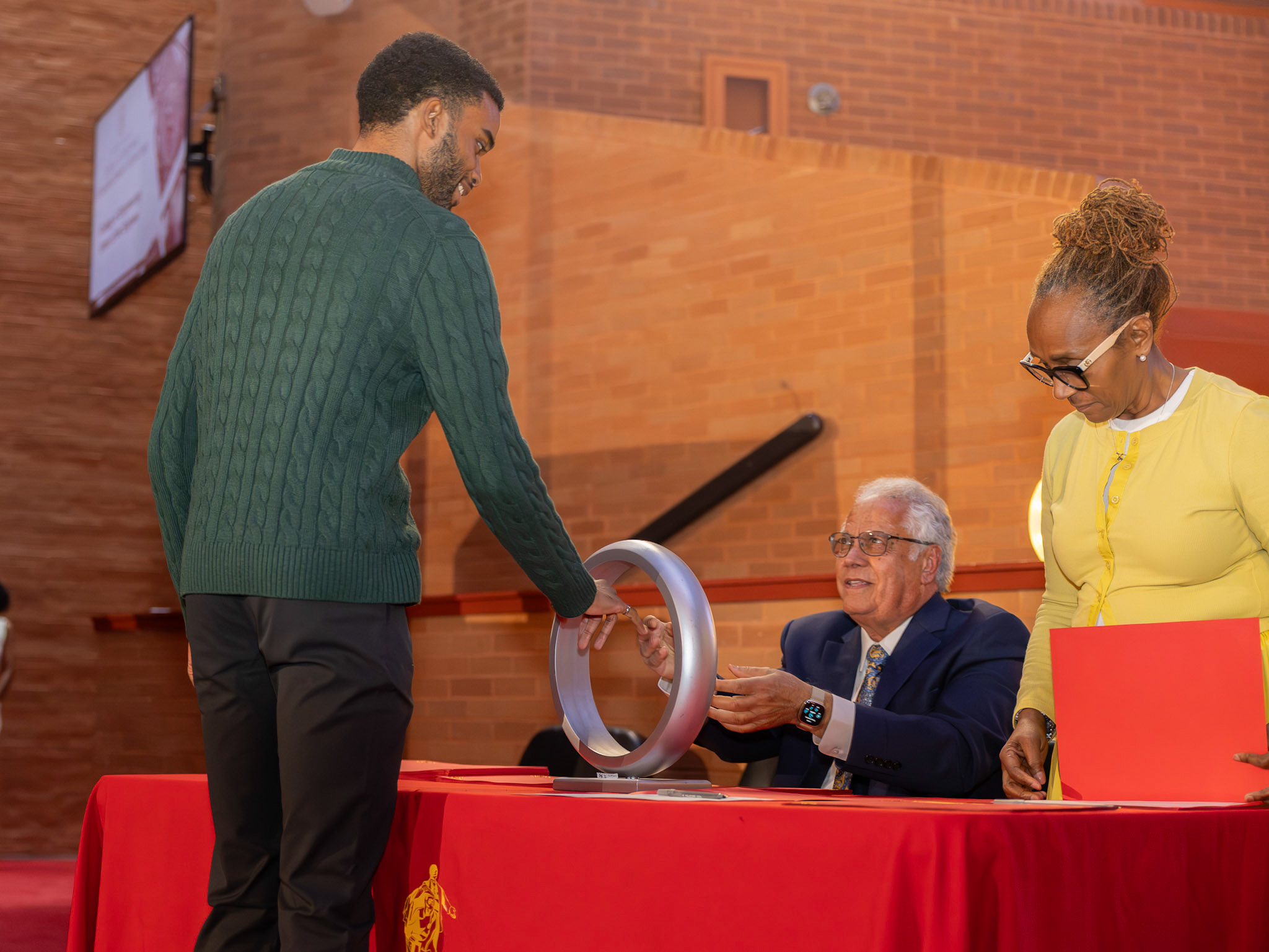 College of Engineering graduating student, Dean and faculty member at the ring ceremony