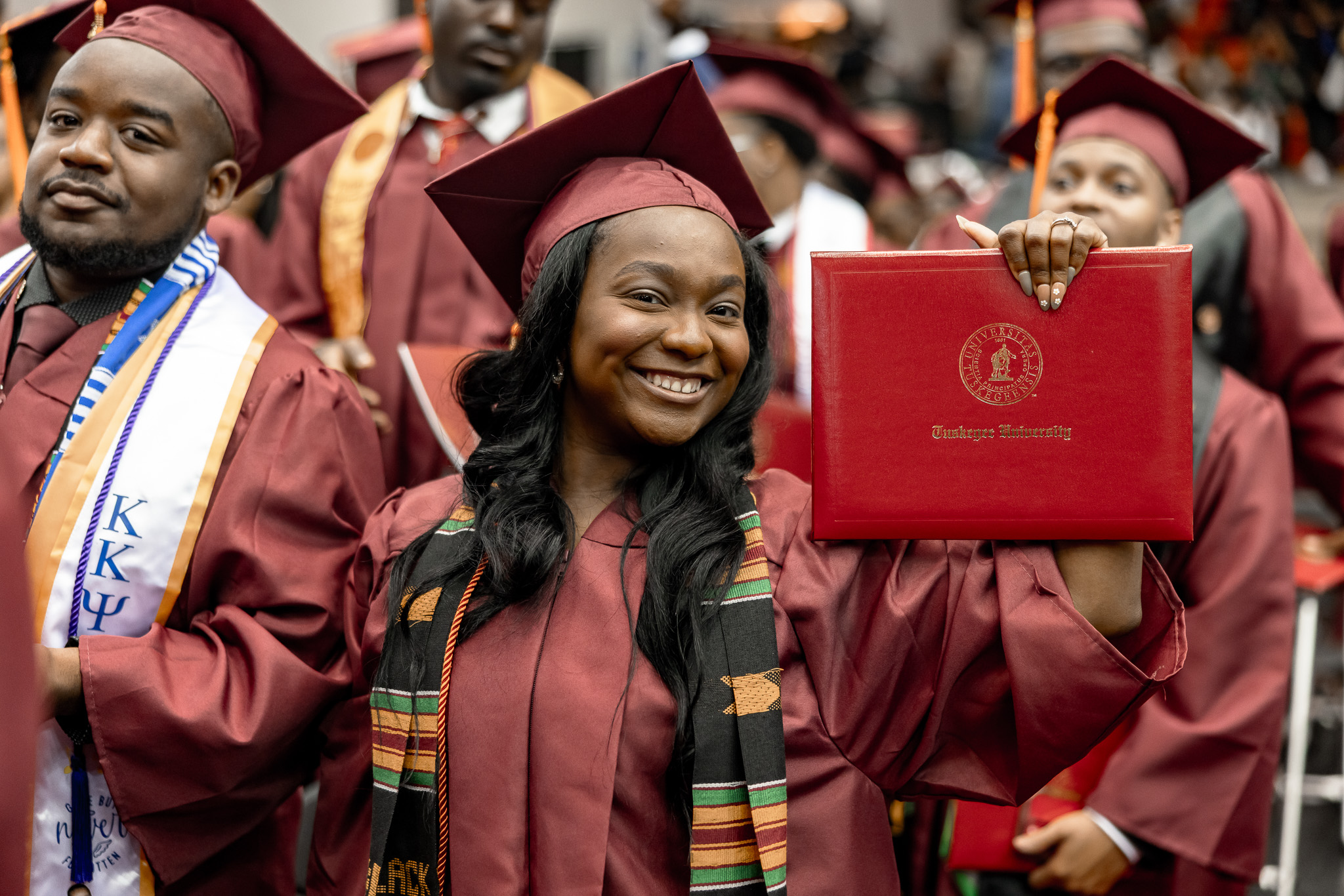 A female graduate holds up diploma
