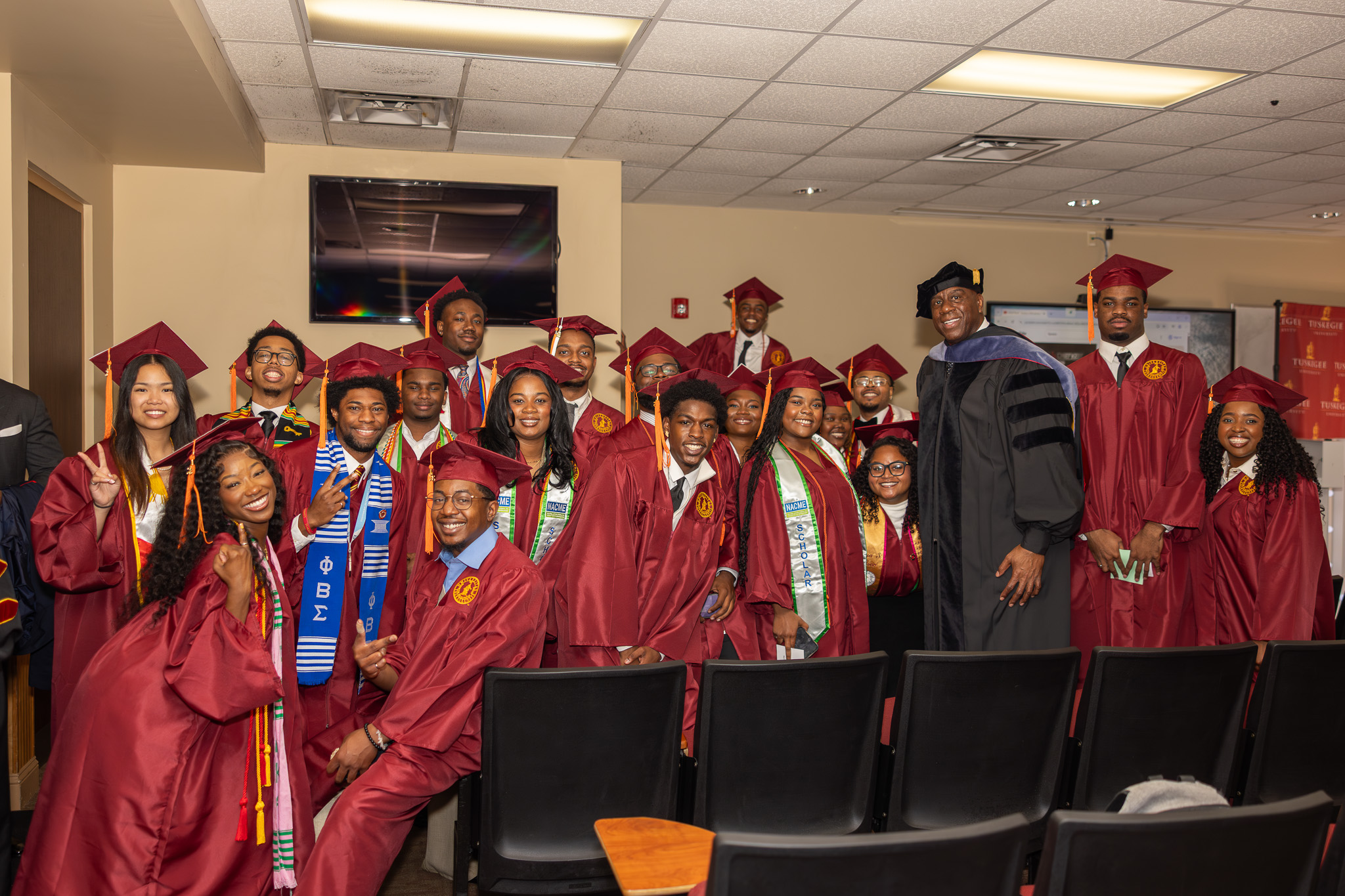 Graduating students pose with Magic Johnson in classroom