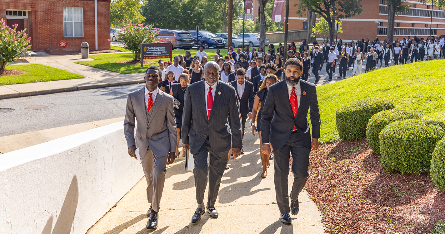 Dr. Brown, Dr. Rice and a student leader leads the procession from the Chapel to the Chappie James Arena