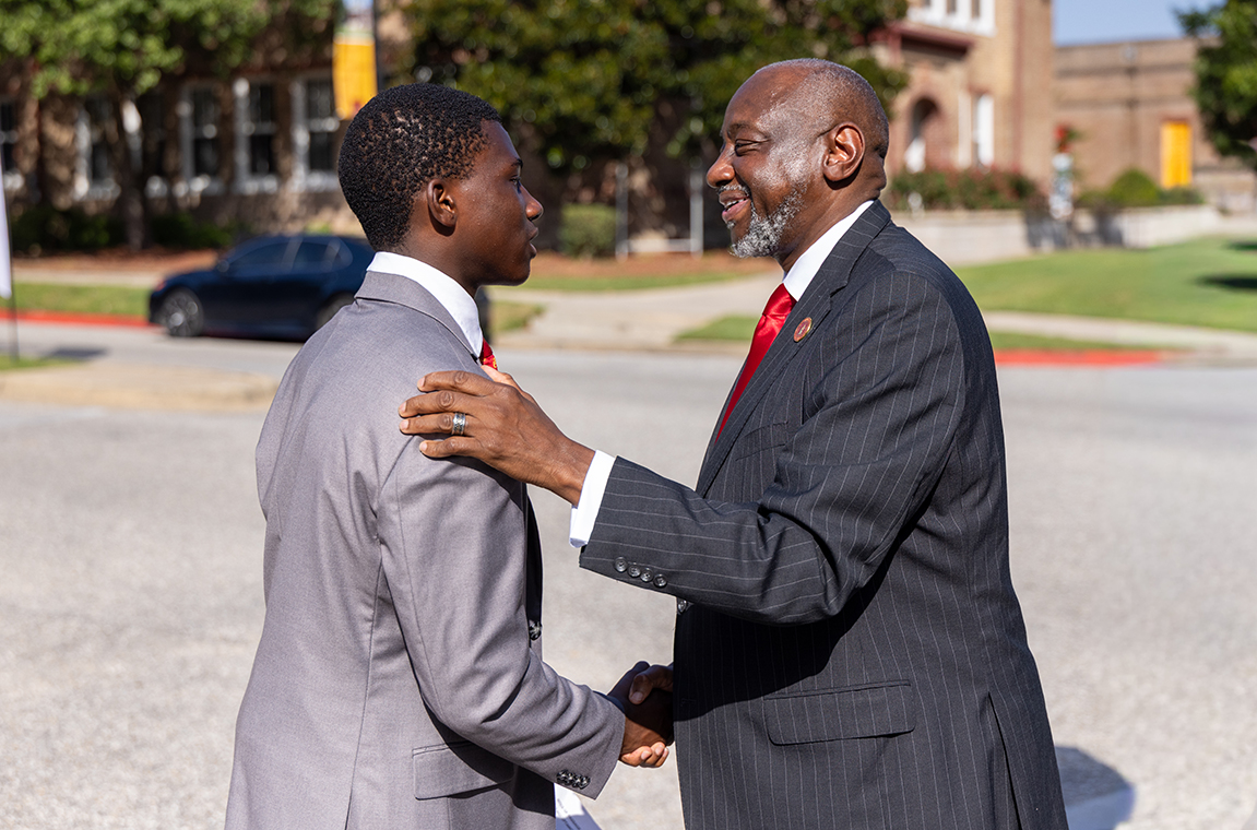 Dr. Brown shakes hands with new student