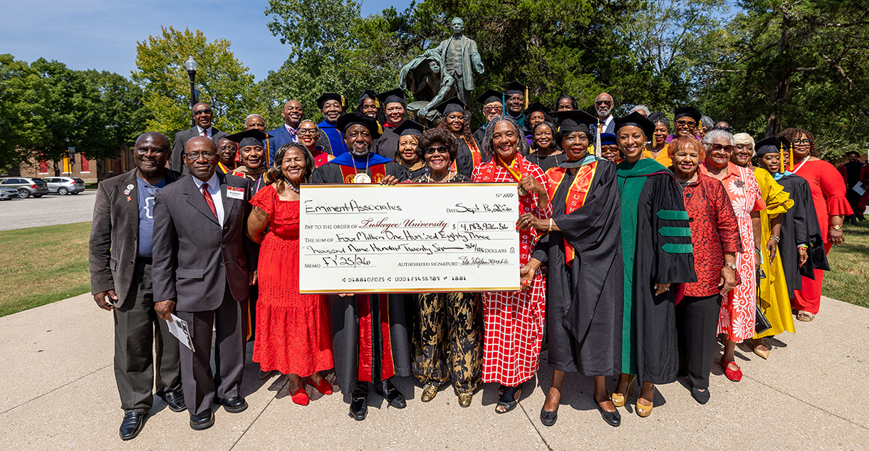 Eminent Associates and Dr. Mark A. Brown holding donation check at the BTW monument