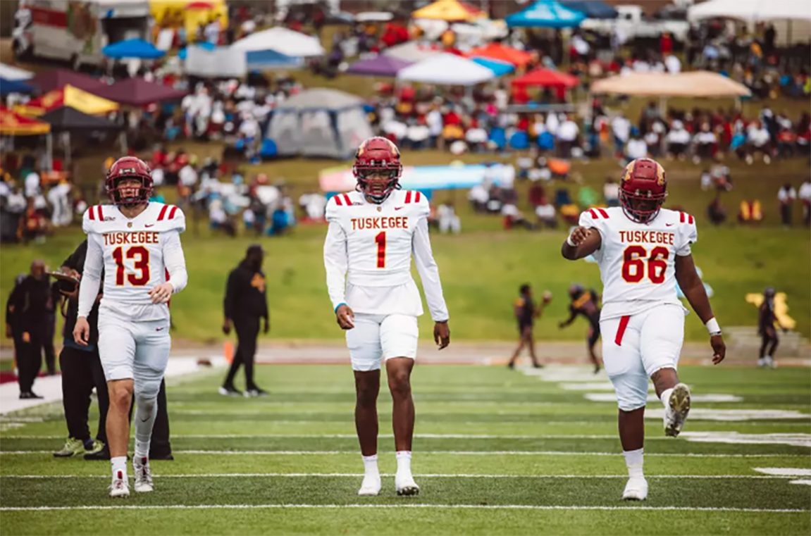 Three TU football players walking out onto the field