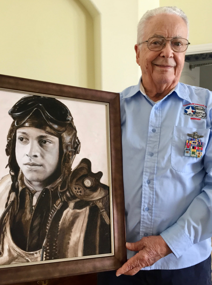 George Hardy holding picture of himself as a Tuskegee Airman