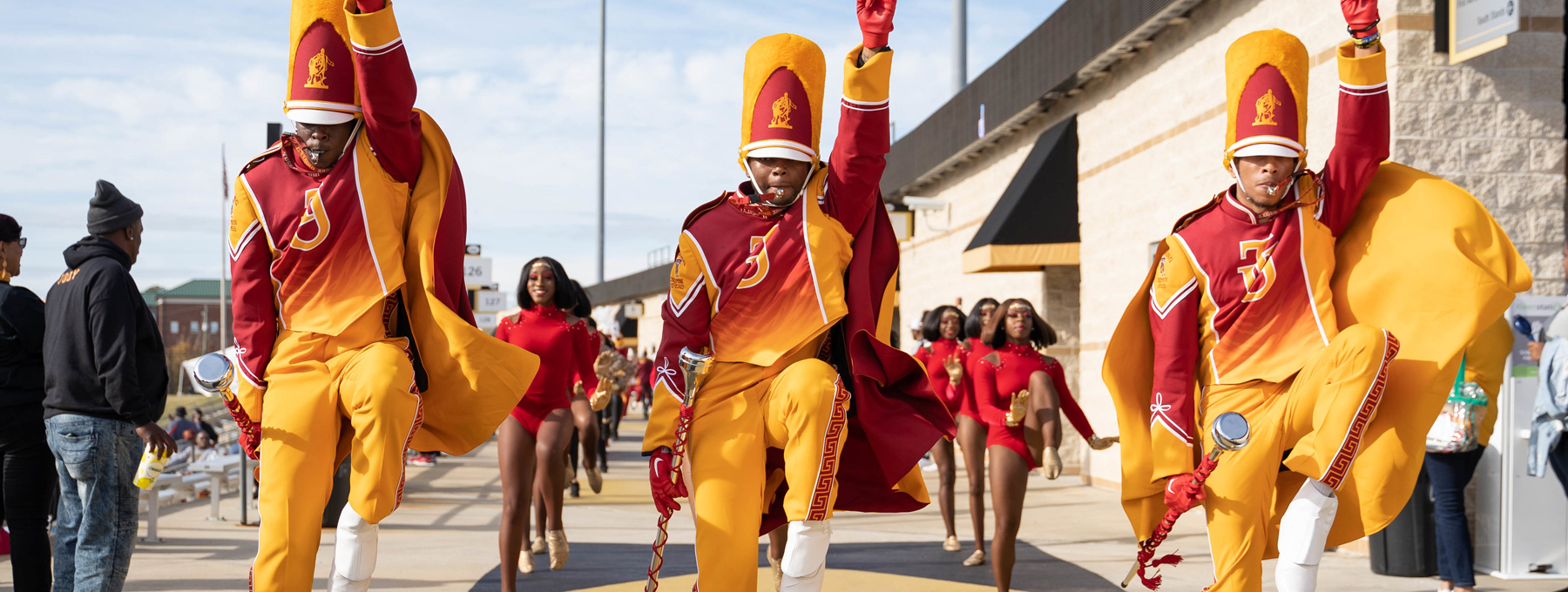 Three high-stepping drum majors